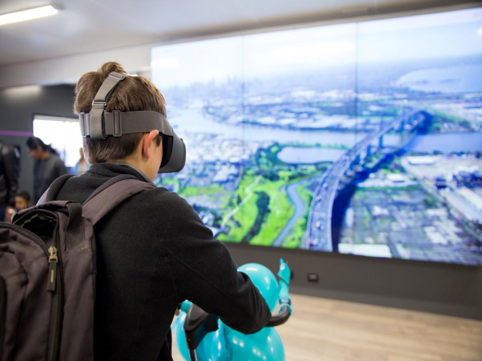 Image of a boy using a virtual reality bike at the West Gate Tunnel information centre