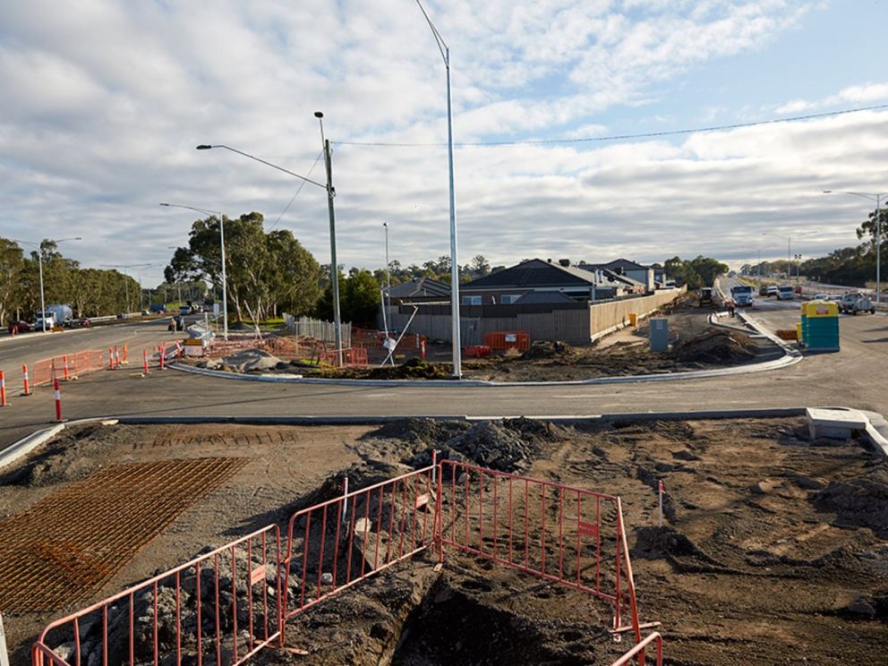 Image of the intersection roadworks being done. Housing in the background is visible as well as diverted traffic