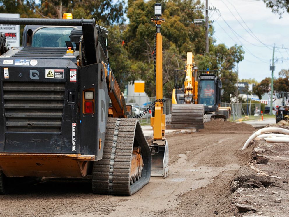 Building the new lanes on Wells Road, focusing on the vehicles moving earth