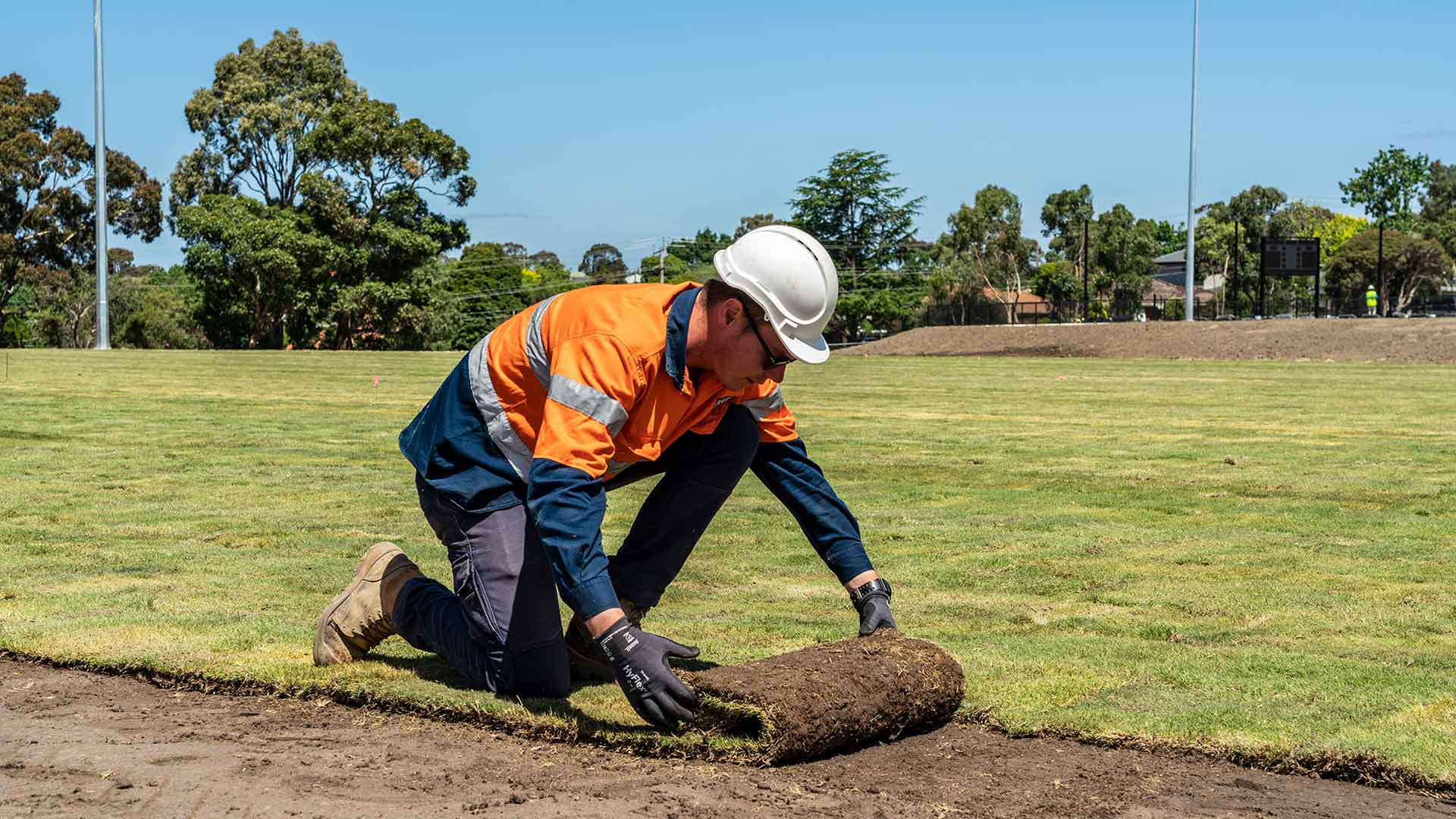 Construction worker laying turf
