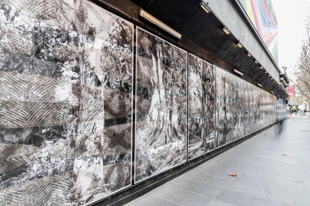 Black and white artwork on construction hoarding on a city street