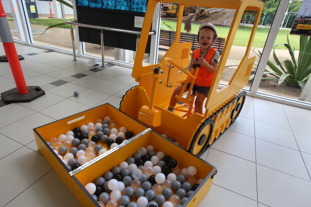 A child digging up balls with a child-sized crane.