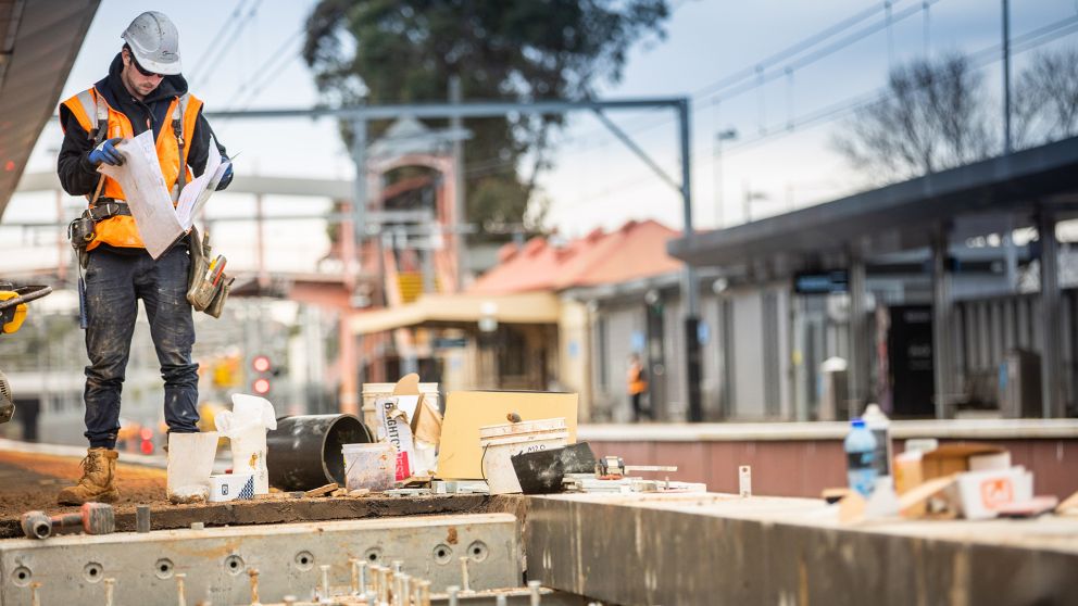 Workers working on an outdoor rail line platform