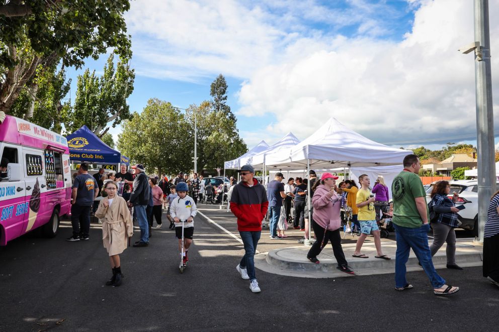 People walking in front of various stalls 