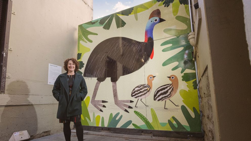 Image of Sarah in front of her Cassowary artwork in Scott Alley.