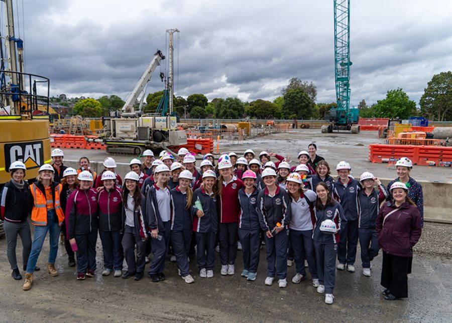 Students posing for a group photo on a Burwood construction site.