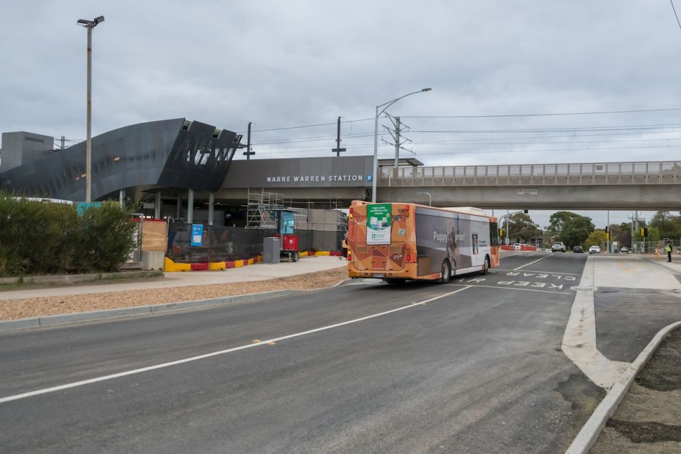 A bus passes under the elevated rail line at Webb Street