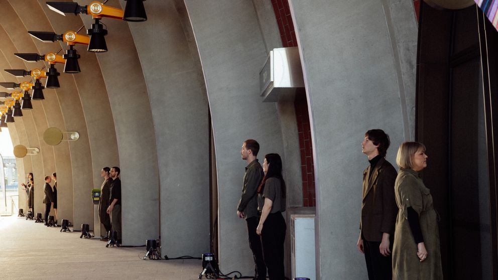 Invenio stand in pairs beneath the arches at Arden Station and facing various directions while they perform