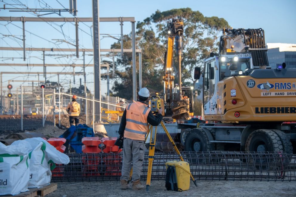 A surveyor works as a piling rig starts drilling one of the piles for the Webster Street level crossing removal project