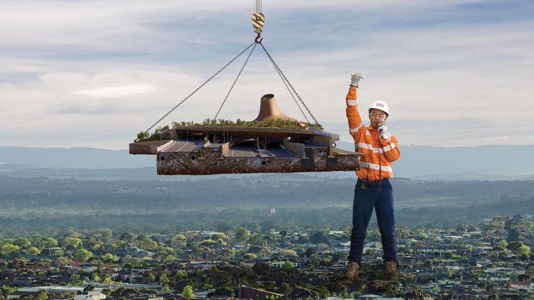 A giant construction worker lowering road into place