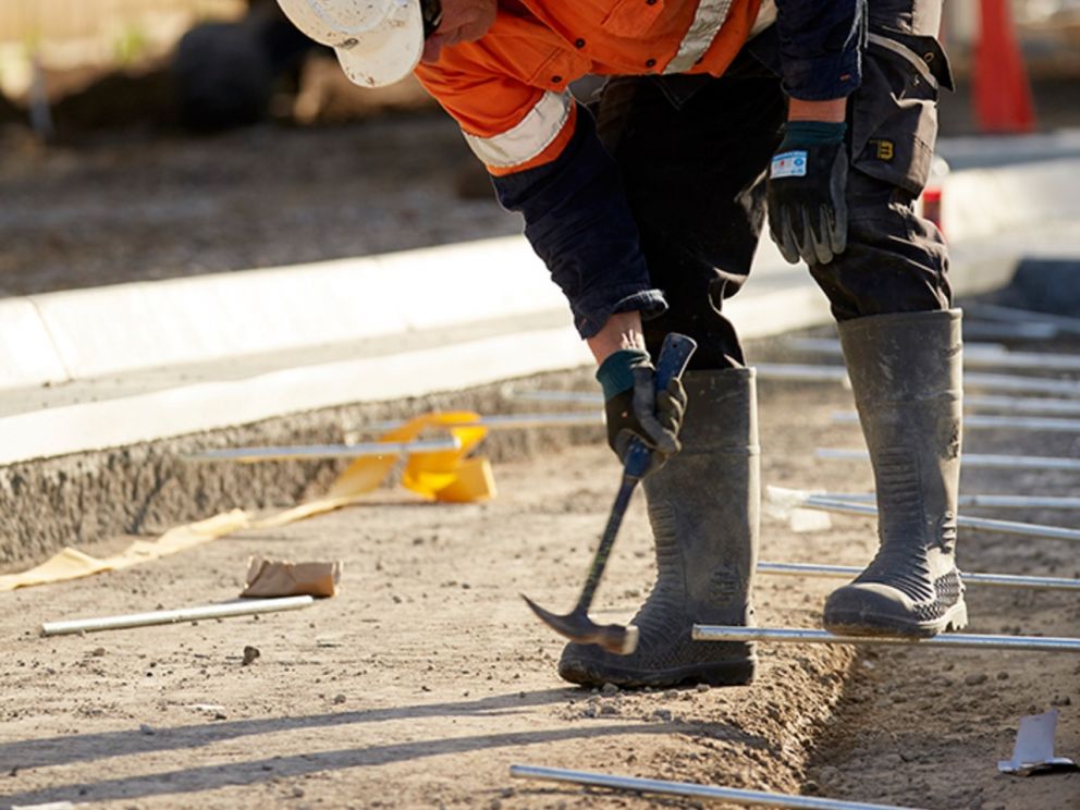 Image of a construction worker hammering on site