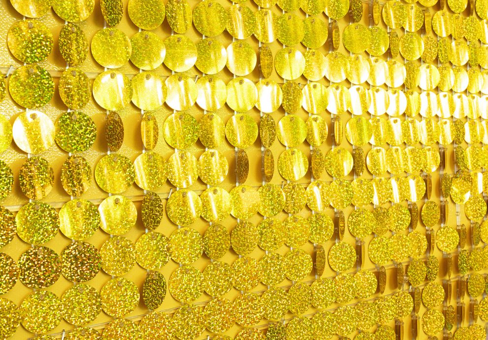 A wall covered in large gold sequins.