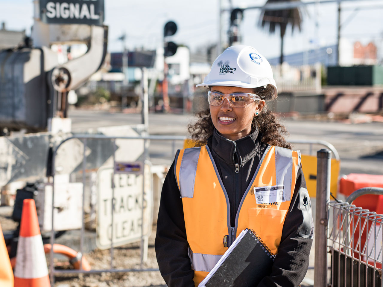 Sam, a GROW program participant standing near a level crossing.