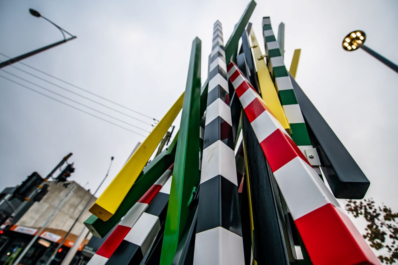 Sculpture installed at Glenroy Station. The sculpture features several striped poles stacked vertically to represent boom gates and the high contrast signage of the recently removed level crossing. 