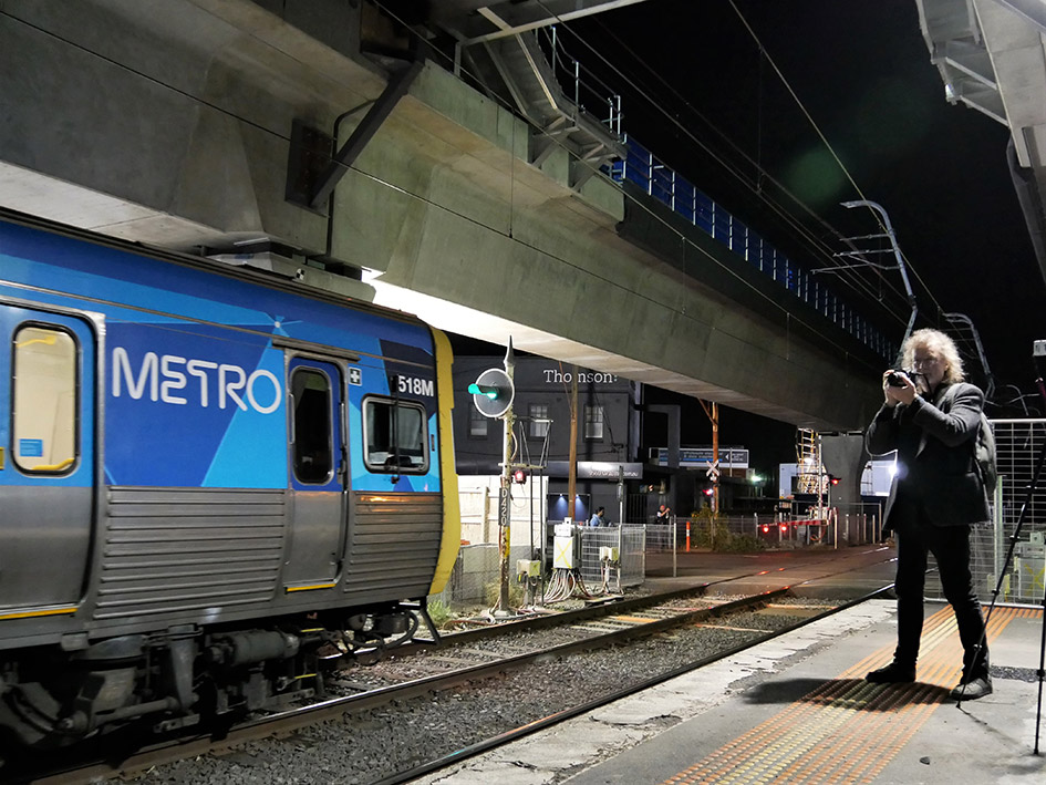 Photographer on Murrumbeena Station with elevated rail ahead