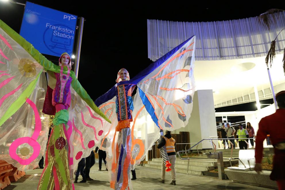 Stilt performers at night at the station