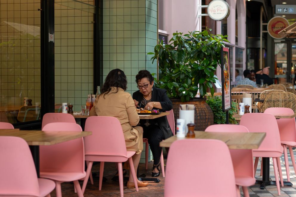 Two women eating a meal in the outdoor dining section of the Glen shopping centre