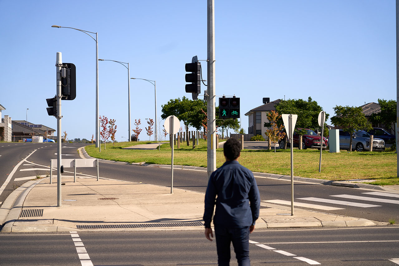 Man crossing at a pedestrian crossing with green light showing