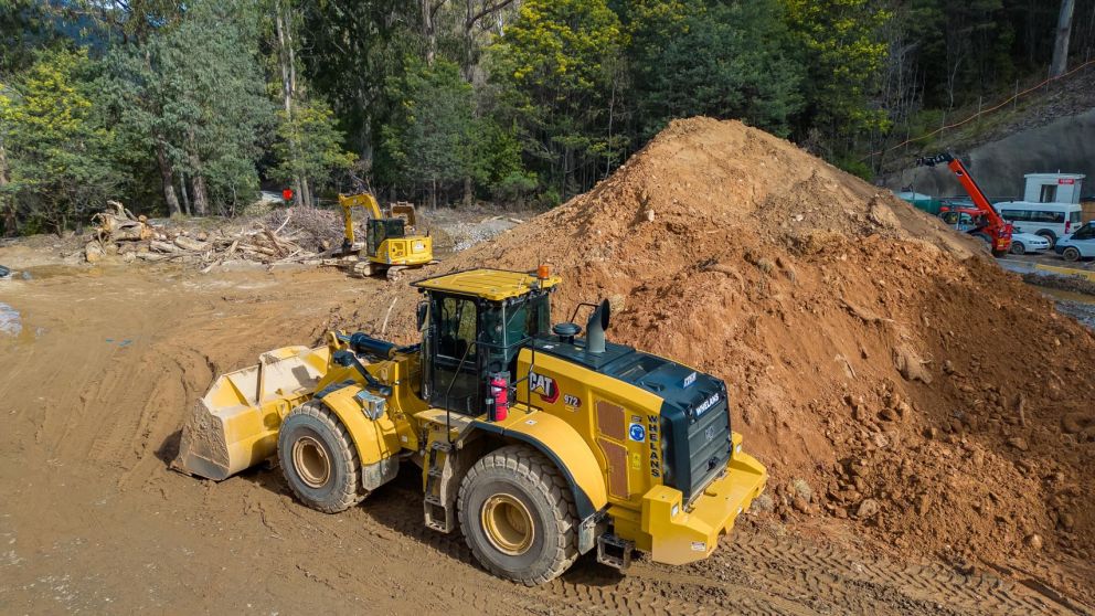 An bulldozer sits next to a stockpile