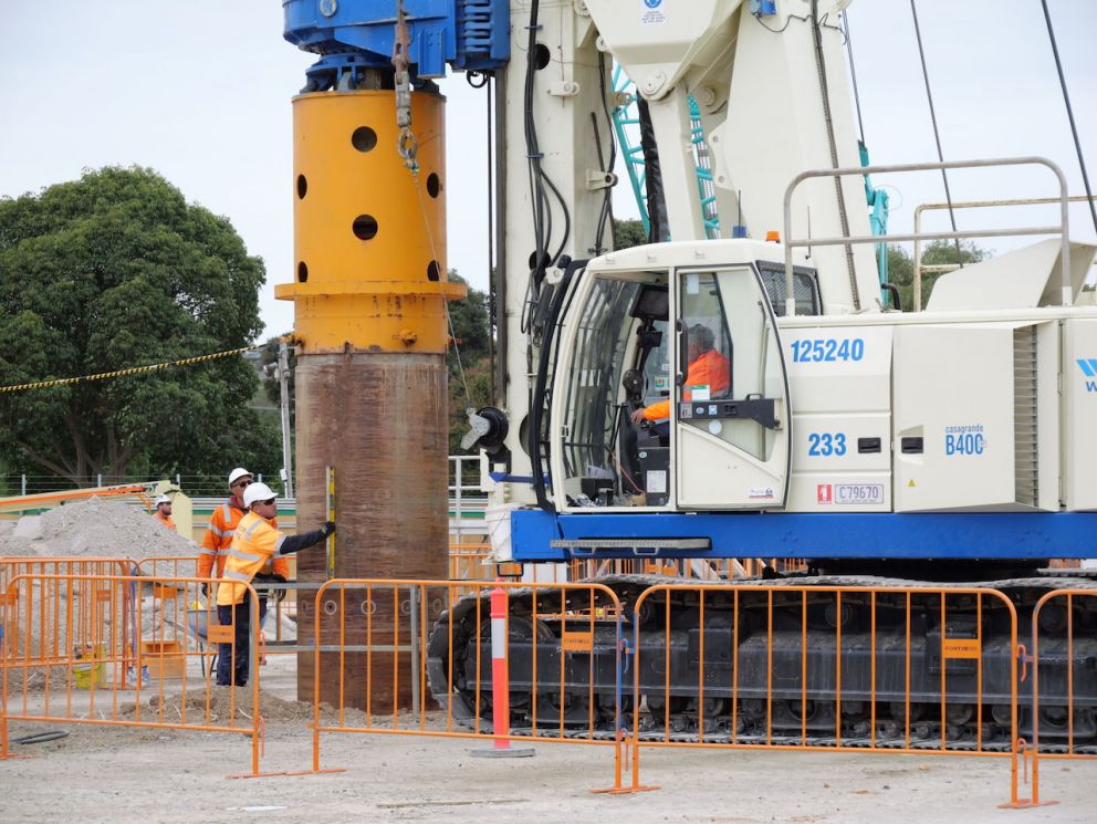 Workers on site drilling a column into the ground.
