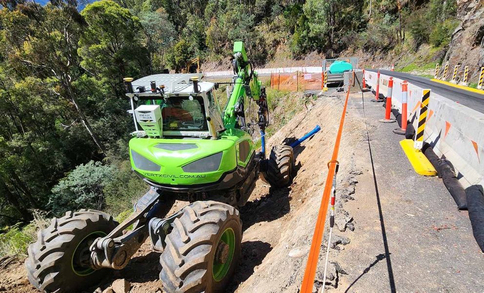 Spider excavator works behind barriers to repair the second smaller landslip on Bogong High Plains Road 