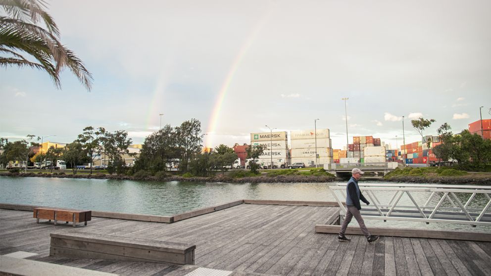 A man walking along the revitalised riverfront at Footscray Wharf.