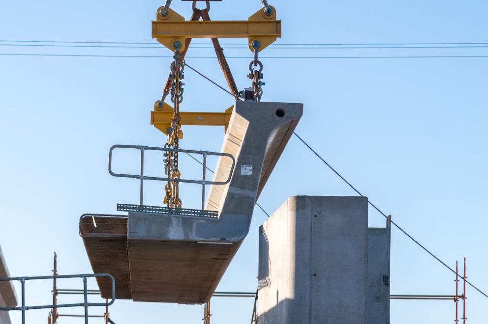 The second L-beam is lifted into place. Two L-beams make a U-trough