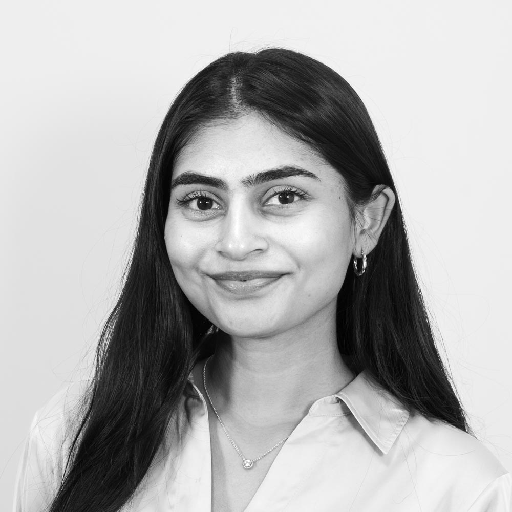 A young smiling woman in a suit.