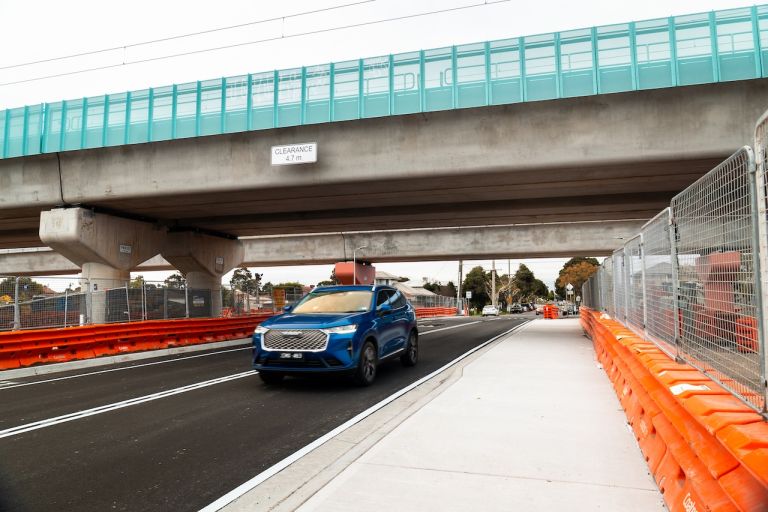 Car travelling under the Maddox Road elevated rail bridge
