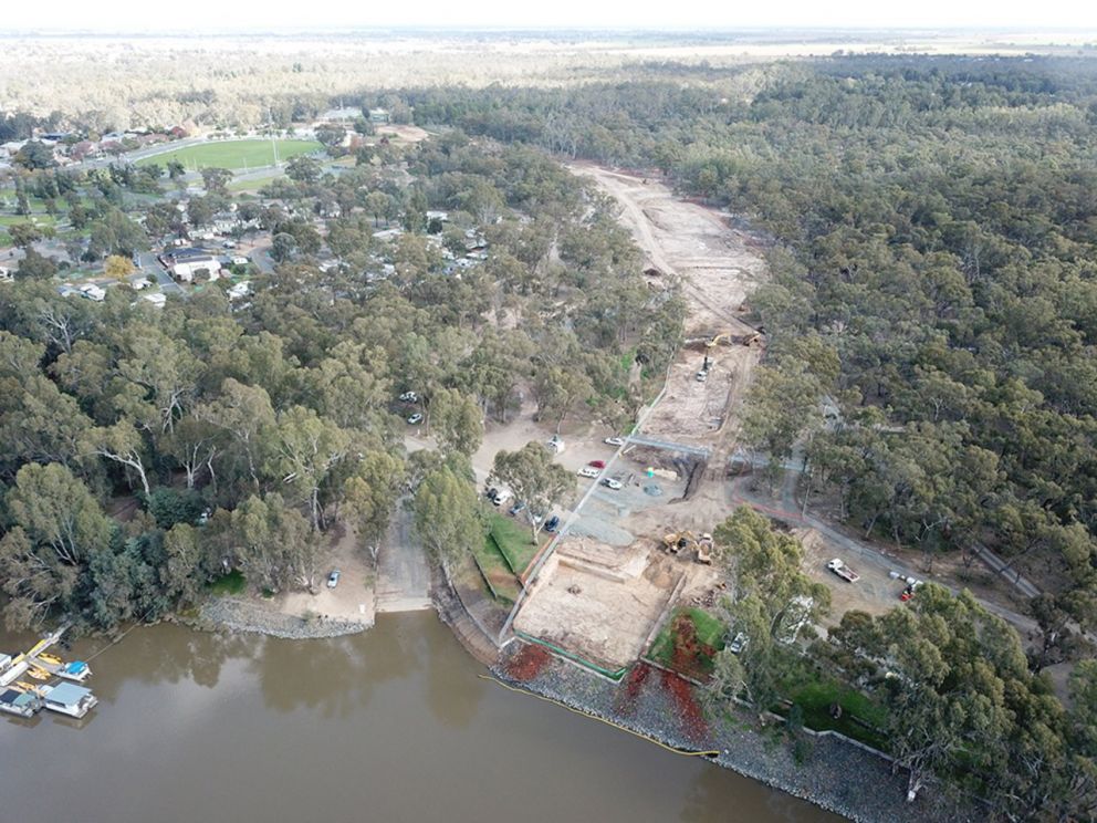Birds eye view of a construction site with a river running across the bottom