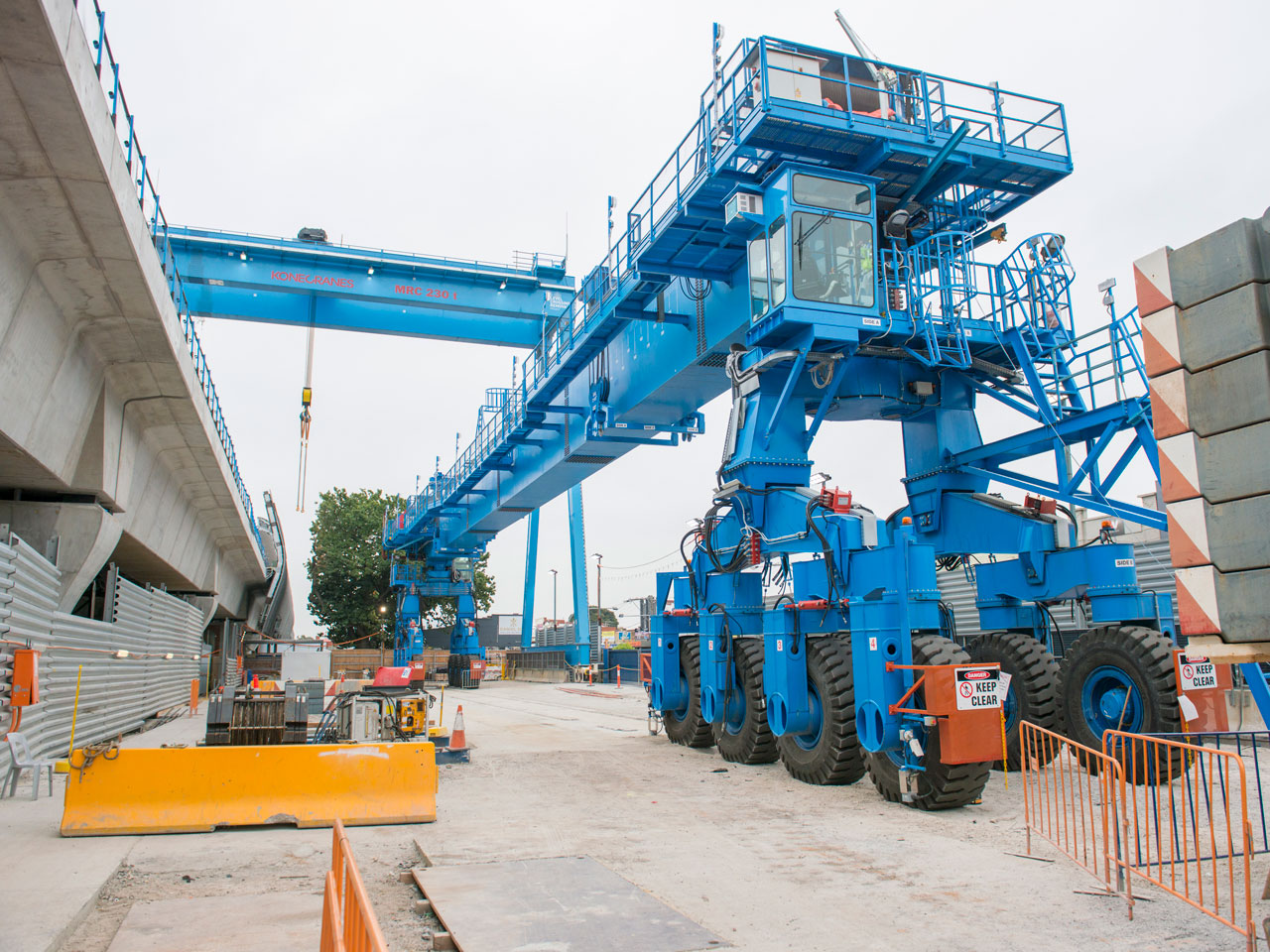 A large blue straddle carrier on the ground.