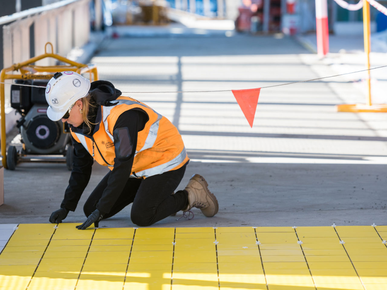A worker laying down the tiles at the new Hoppers Crossing pedestrian overpass.