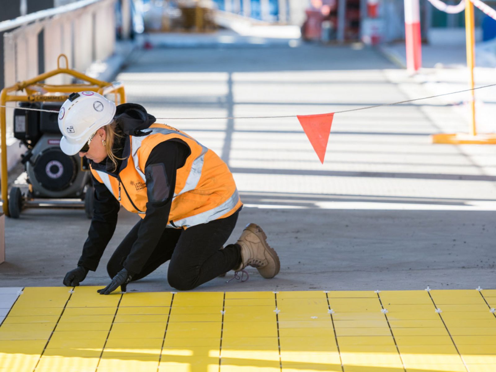 A worker laying down the tiles at the new Hoppers Crossing pedestrian overpass.