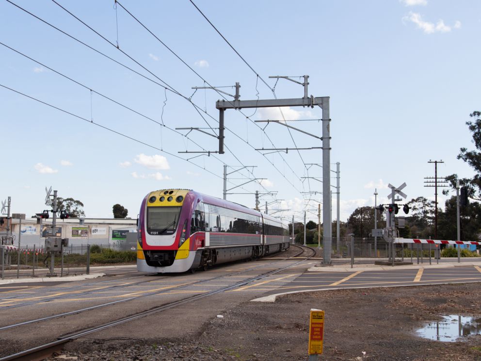 A V/Line train passing through the Clyde Road level crossing.