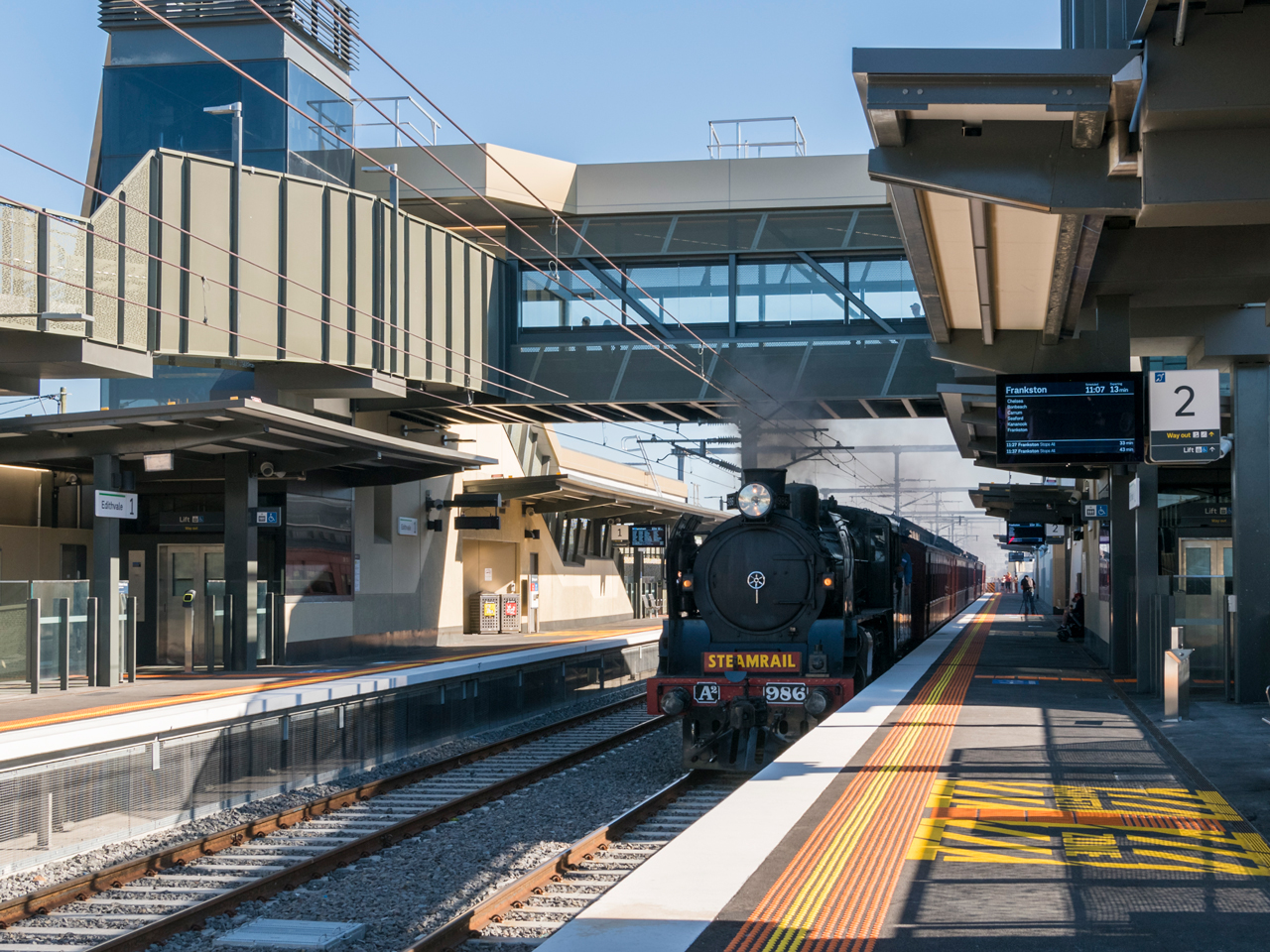 Steam train going past the lowered Edithvale Station.