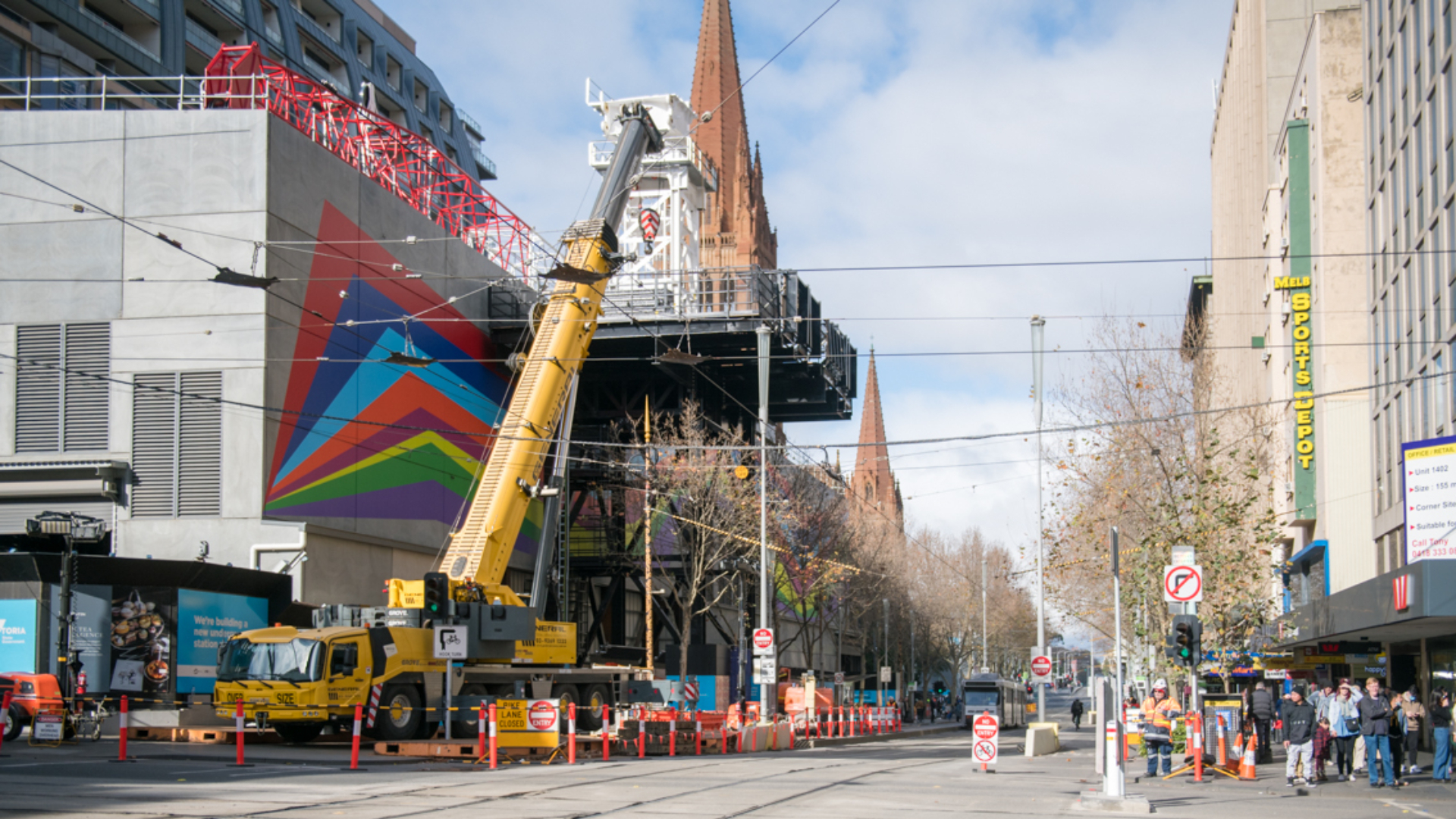 A tall crane is visible on Swanston Street at the Town Hall Station site