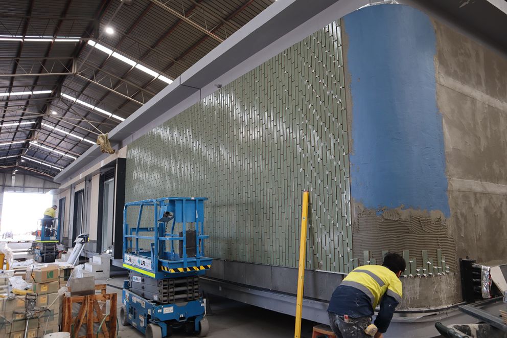 Affixing external cladding to station buildings