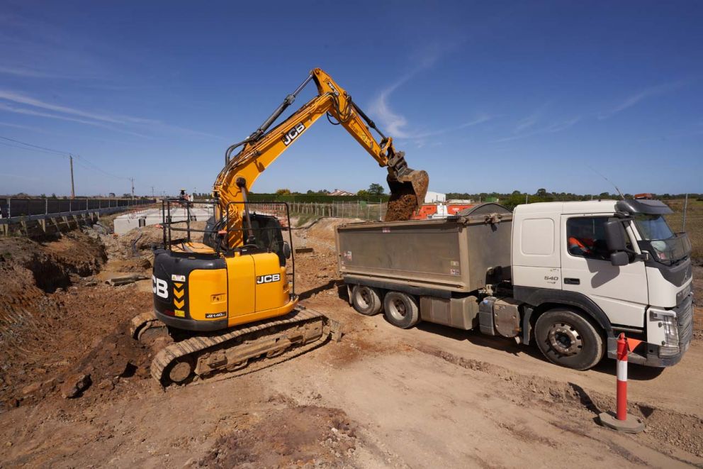 A dirt-digger placing excavated material into a tandem in preparation for export to a stockpile area