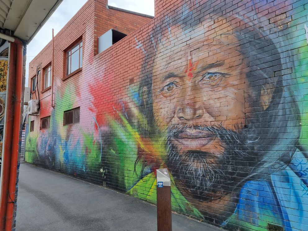 Mary street laneway art of a bearded man surround by an explosion of colour 