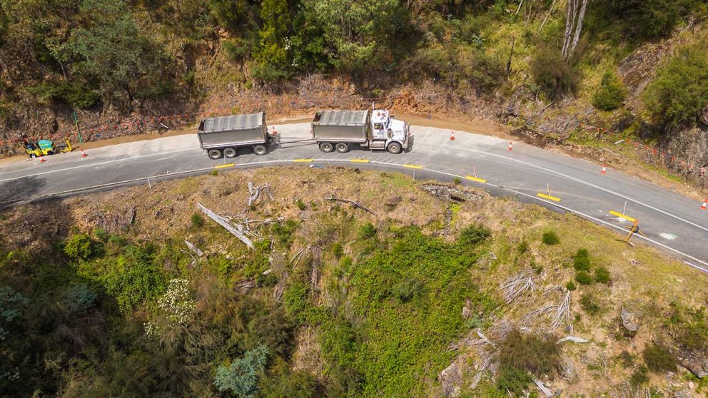 A truck moves carefully through traffic management set up at the second smaller landslip