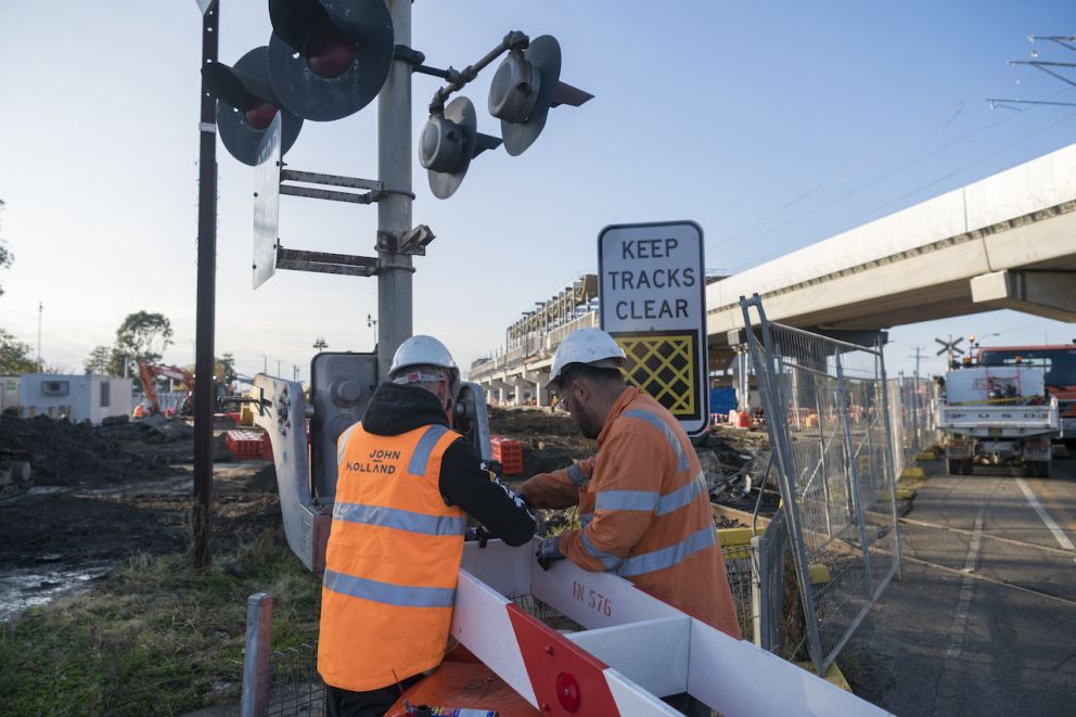 Two workers dismantling the Main Street boom gates