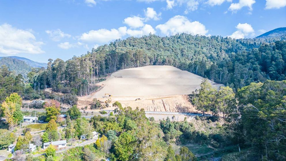 Wide view towards the landslip showing machines clearning near the base closest to Bogong High Plains Road