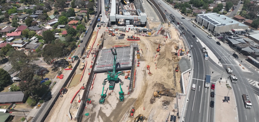 Aerial view of a construction site featuring large machinery and a bridge under assembly