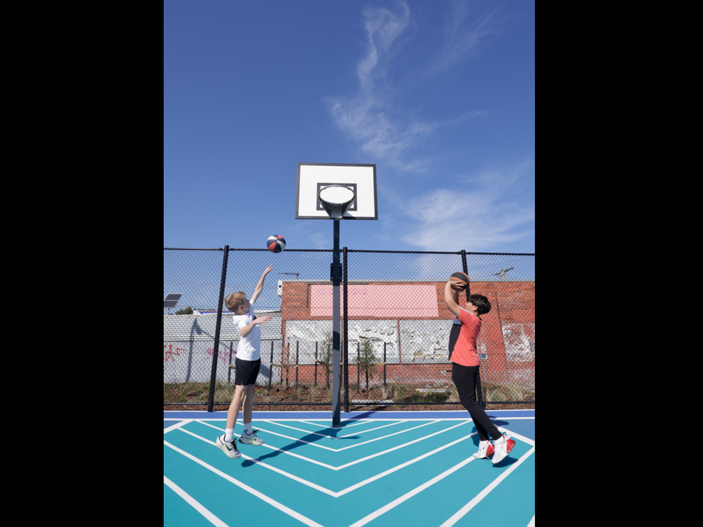 Kids playing basketball on court. 