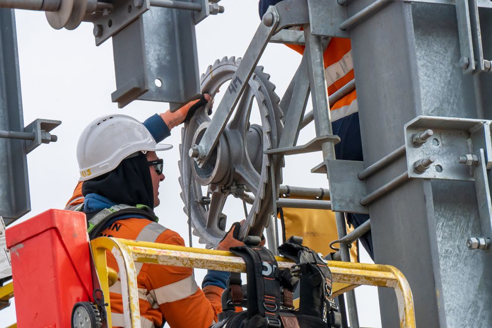 A worker adjusts the tension of the overhead wiring during a construction blitz