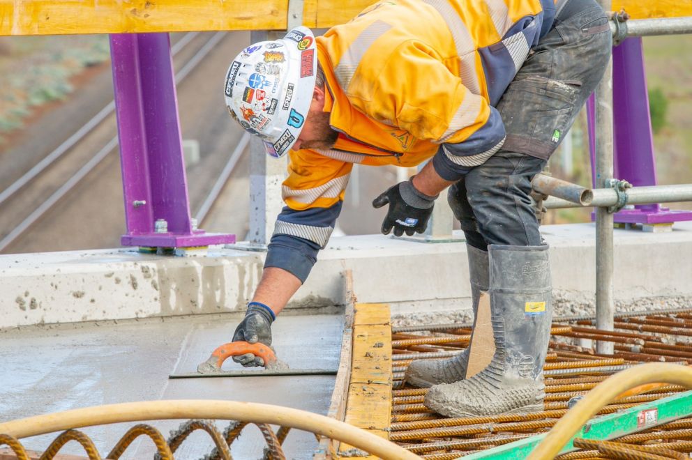 Crews finishing the concrete with a trowel for a smooth finish at Hopkins Road