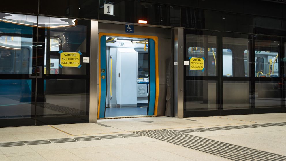 A train at a Metro Tunnel station with open doors and the platform screen doors open in front
