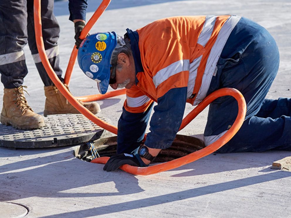 Image of two construction workers working on a drain