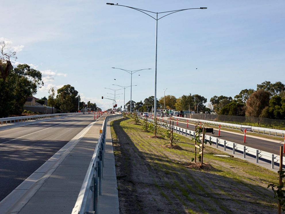 Image shows the new road on both sides with trees being planted in the middle where Hallam Road lights are located