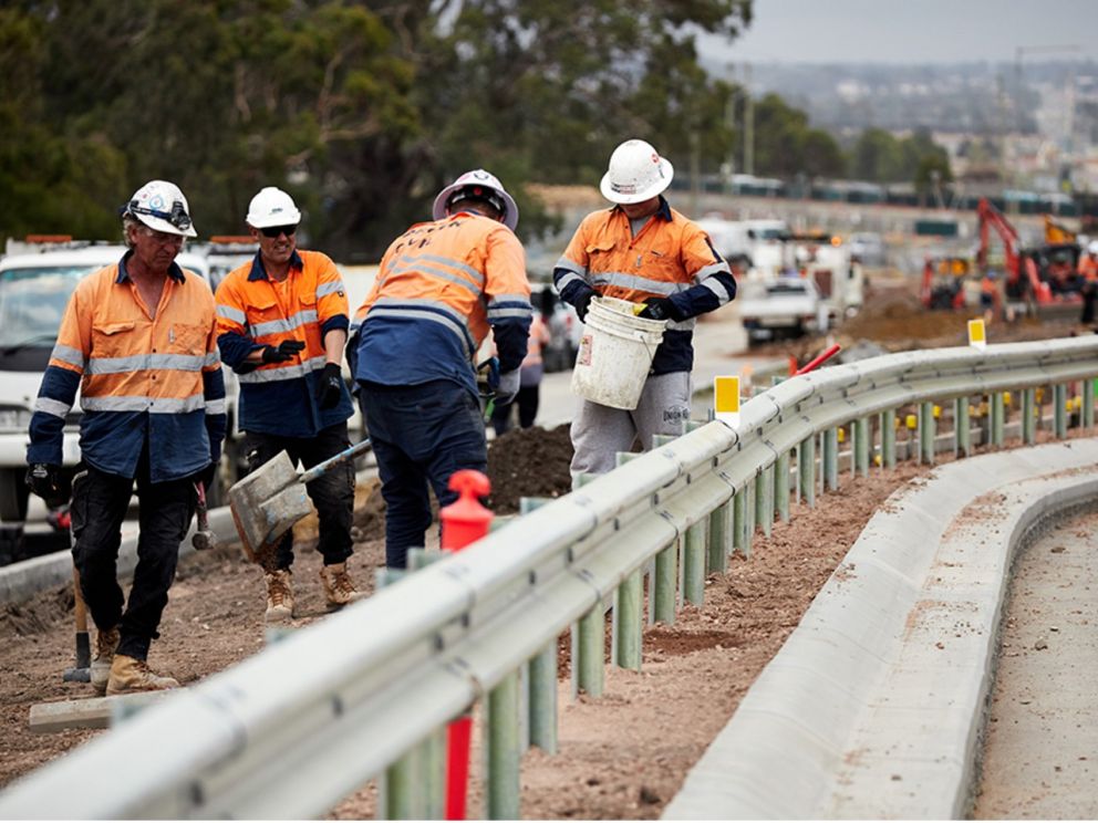 Image of construction workers with shovels and buckets working alongside the road